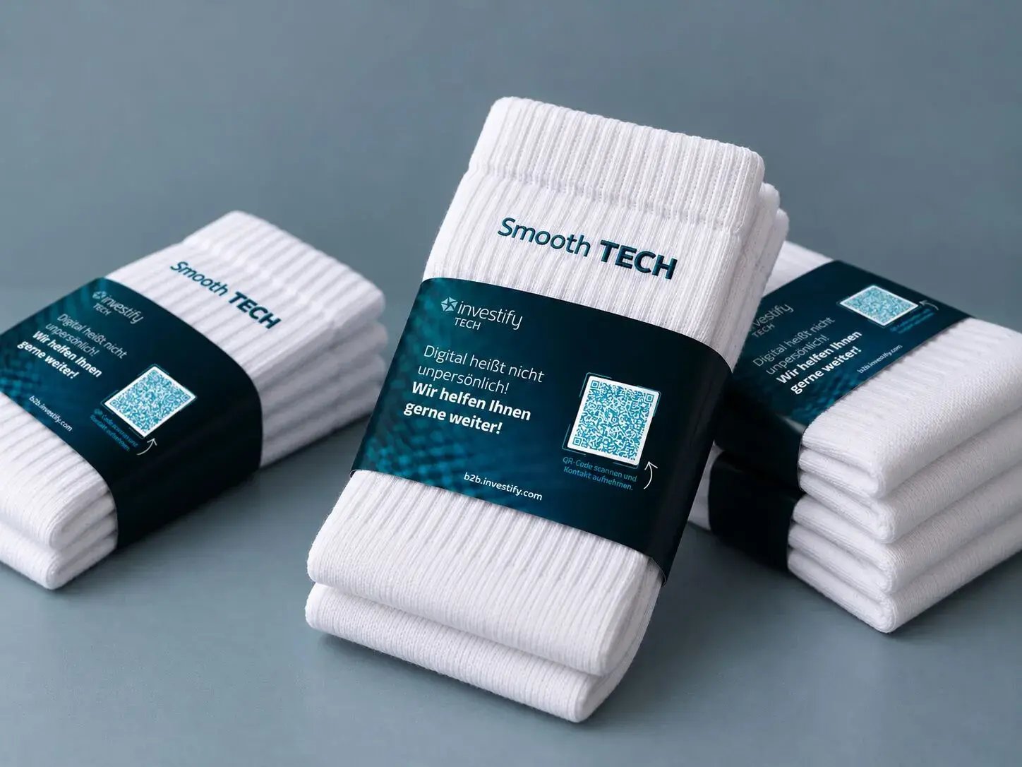 Mehrere Paar weiße Socken mit der Smooth-TECH-Banderole von investify TECH